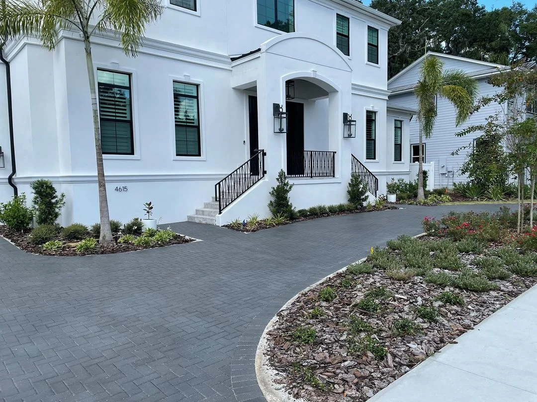 Gray permeable pavers on driveway and entry courtyard with concrete edging and landscaping beds